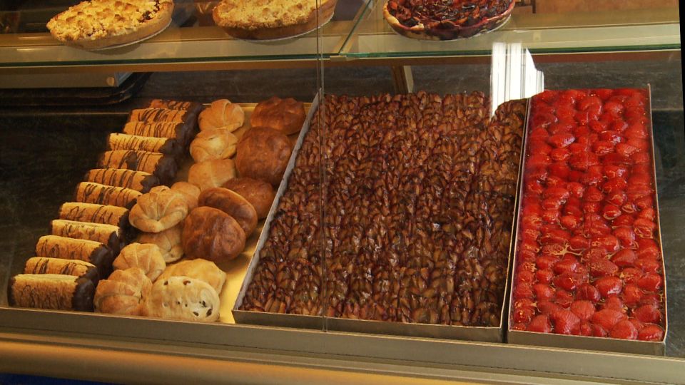 Blick auf die Auslage einer Konditorei mit verschiedenen Sorten Kuchen und Brötchen.